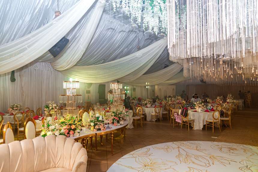 A full banquet under a ceiling of hanging bulbs and cascading florals.